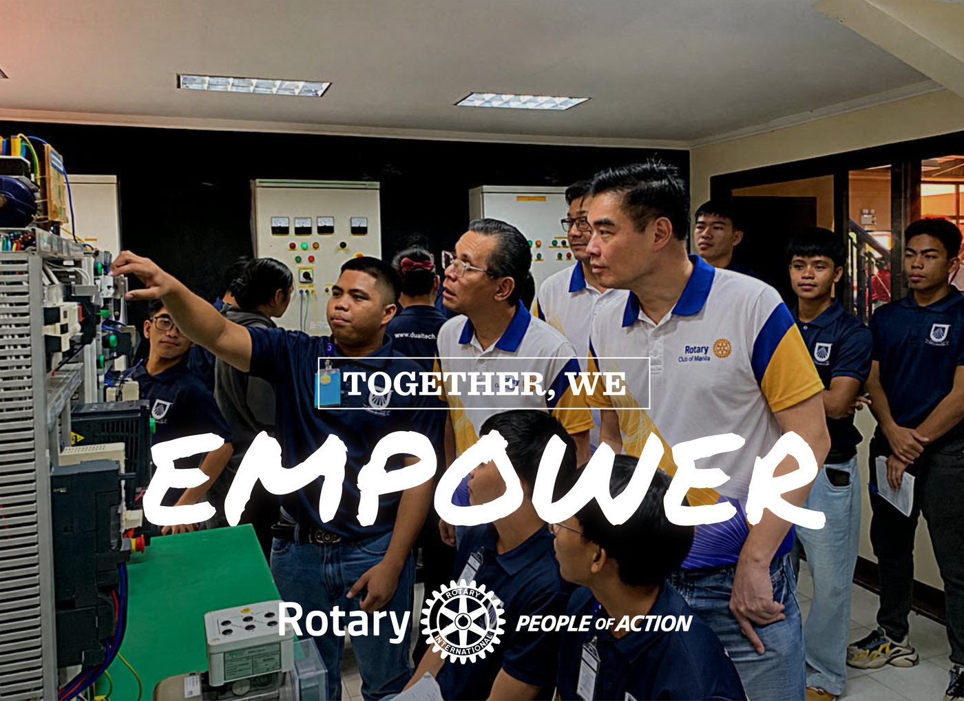 A trainee shows Rotarians an industrial training rig at Dualtech. Text: Together, we empower. Rotary, People of Action.