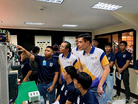 A trainee walks the Rotarians through an industrial training rig.