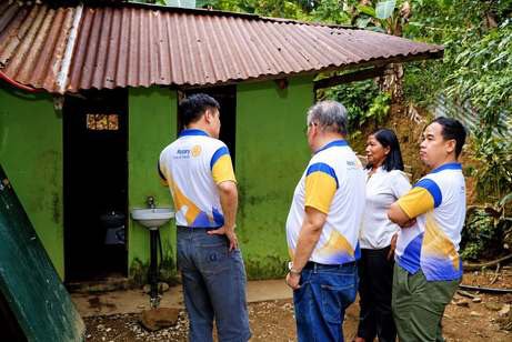 Rotarians inspect the school’s comfort rooms, one of the repairs the Club has committed to.