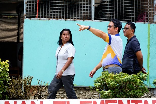 Director Nico Valencia and his engineer survey the school grounds with the School Head to assess the repairs needed.