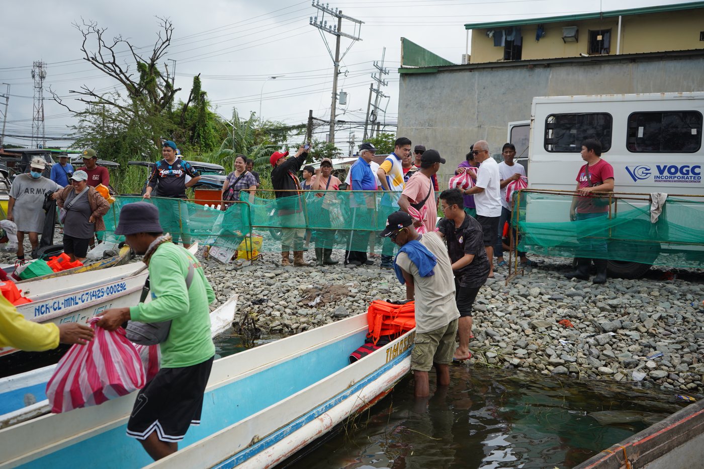 Volunteers load relief bags onto boats, the only way to reach Barangays Gugo, Santa Lucia and Bulusan while floodwater cut them off, September 2026.