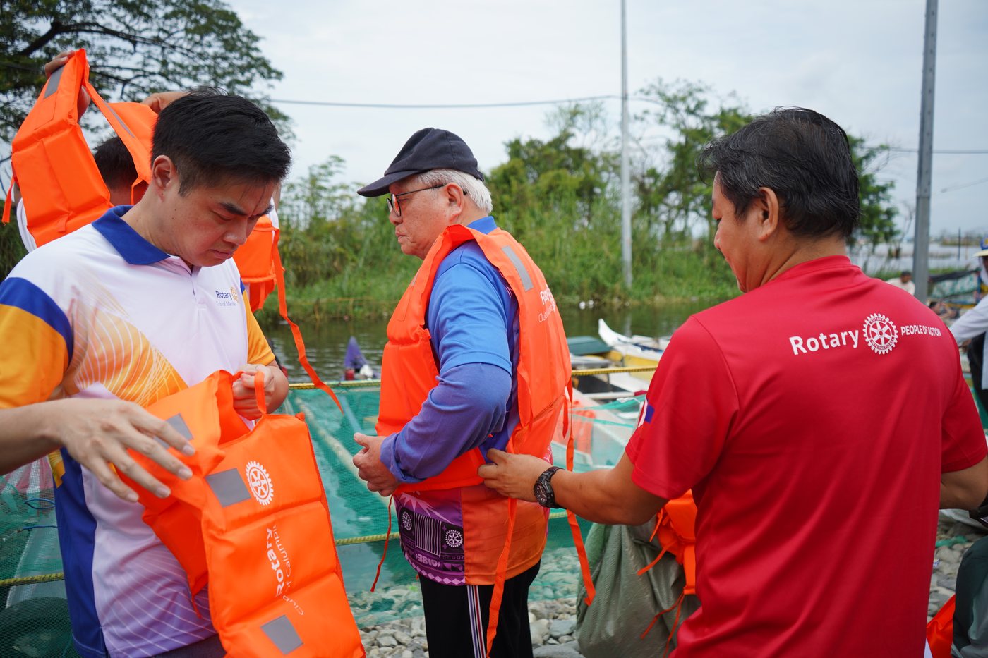 Members of the Rotary Clubs of Manila and Calumpit put on life vests before heading out by boat to the flooded barangays.